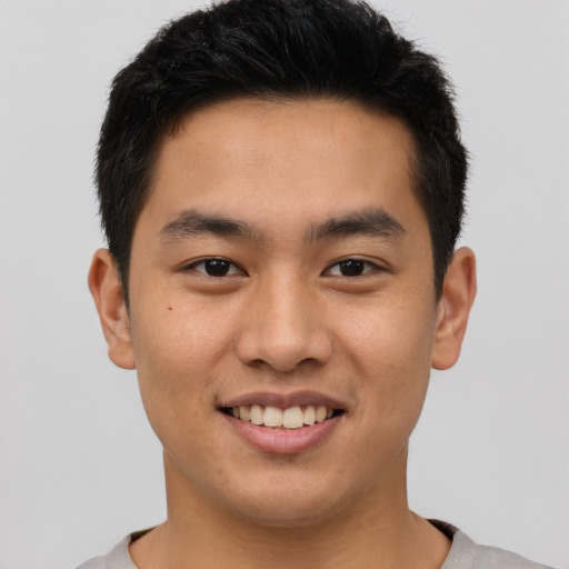 Joyful asian young-adult male with short  brown hair and brown eyes