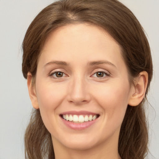 Joyful white young-adult female with long  brown hair and brown eyes