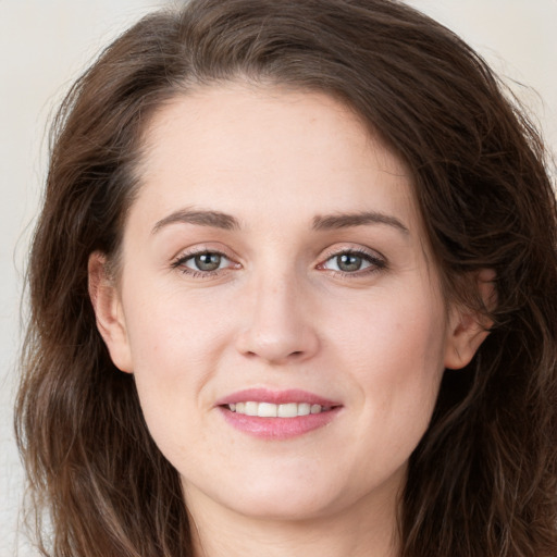 Joyful white young-adult female with long  brown hair and green eyes