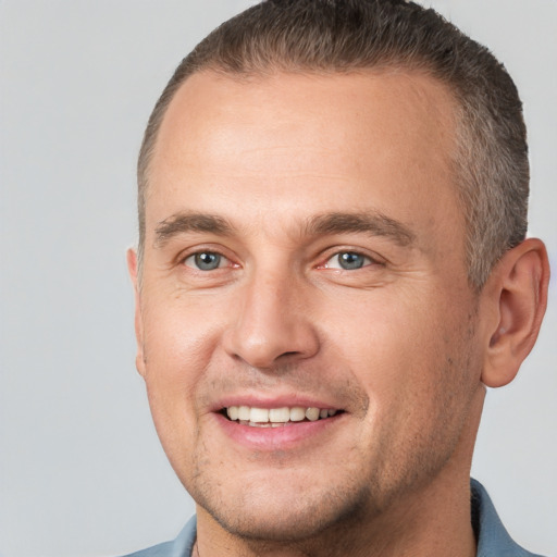 Joyful white adult male with short  brown hair and brown eyes