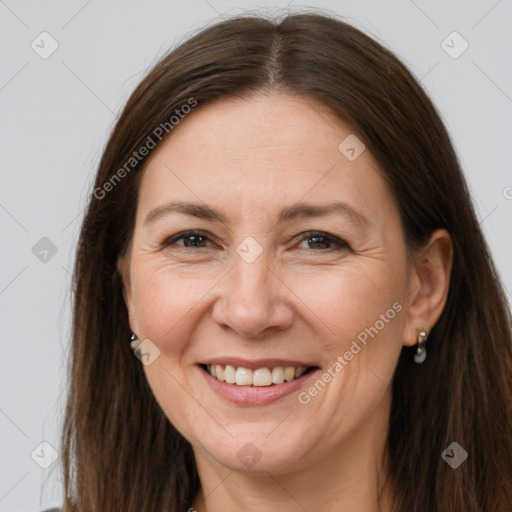 Joyful white adult female with long  brown hair and brown eyes