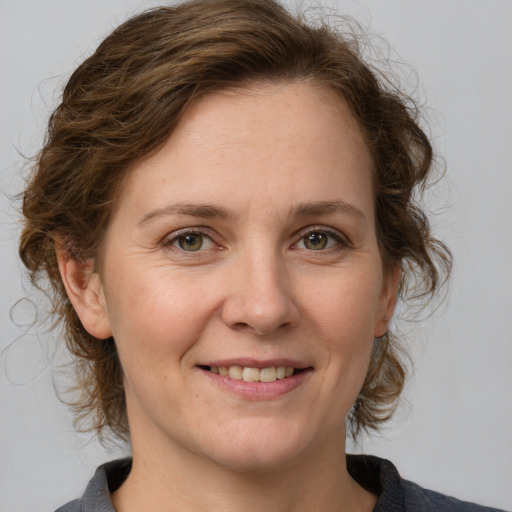 Joyful white adult female with medium  brown hair and grey eyes