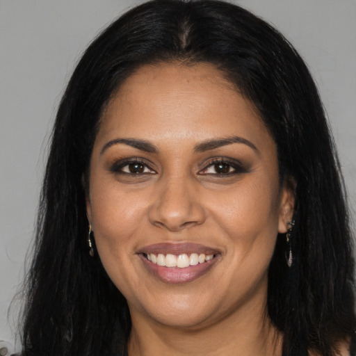 Joyful black young-adult female with long  brown hair and brown eyes