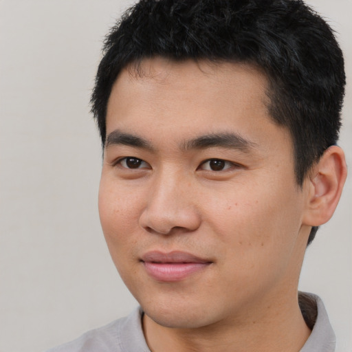 Joyful asian young-adult male with short  brown hair and brown eyes