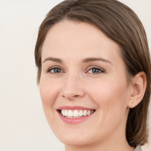 Joyful white young-adult female with medium  brown hair and green eyes