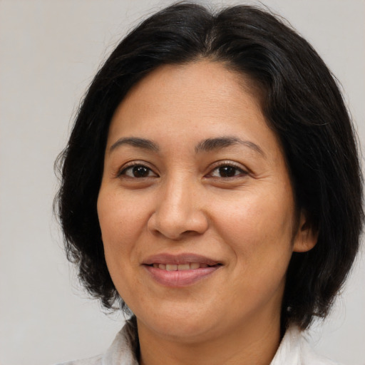 Joyful latino adult female with medium  brown hair and brown eyes