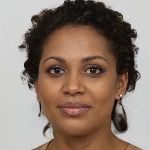 Joyful black young-adult female with medium  brown hair and brown eyes