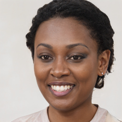 Joyful black young-adult female with short  black hair and brown eyes