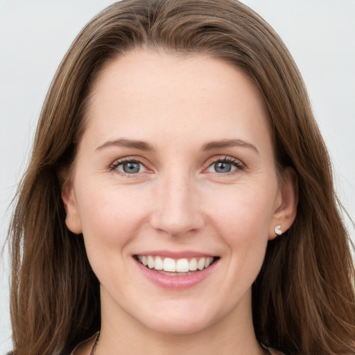 Joyful white young-adult female with long  brown hair and grey eyes