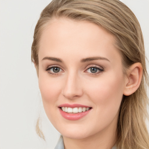 Joyful white young-adult female with long  brown hair and blue eyes