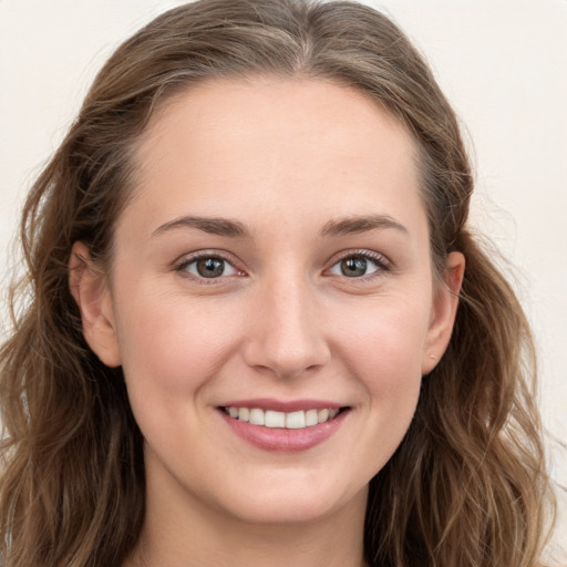 Joyful white young-adult female with long  brown hair and grey eyes