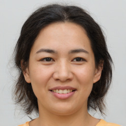 Joyful asian young-adult female with medium  brown hair and brown eyes