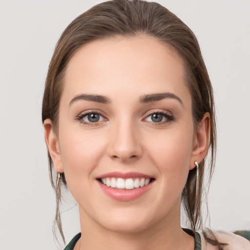 Joyful white young-adult female with medium  brown hair and grey eyes