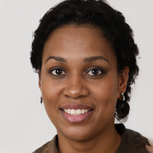 Joyful black young-adult female with long  black hair and brown eyes