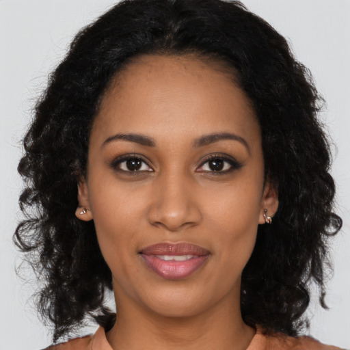 Joyful black young-adult female with long  black hair and brown eyes
