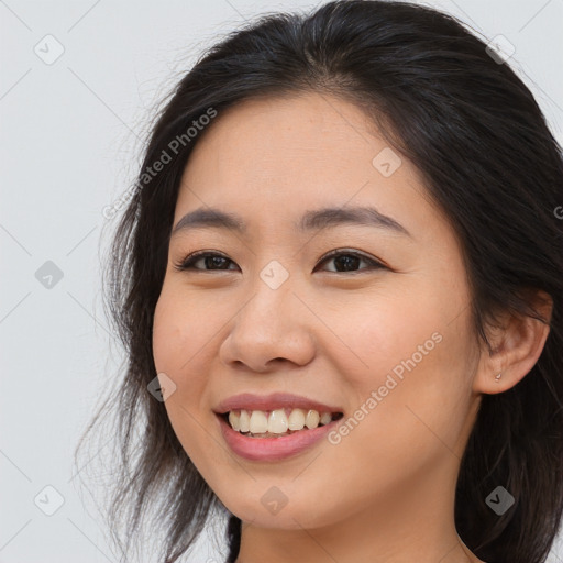 Joyful asian young-adult female with long  brown hair and brown eyes