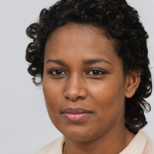Joyful black young-adult female with long  brown hair and brown eyes