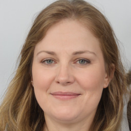 Joyful white adult female with long  brown hair and brown eyes