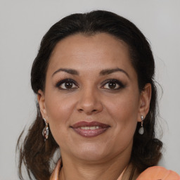 Joyful latino adult female with medium  brown hair and brown eyes