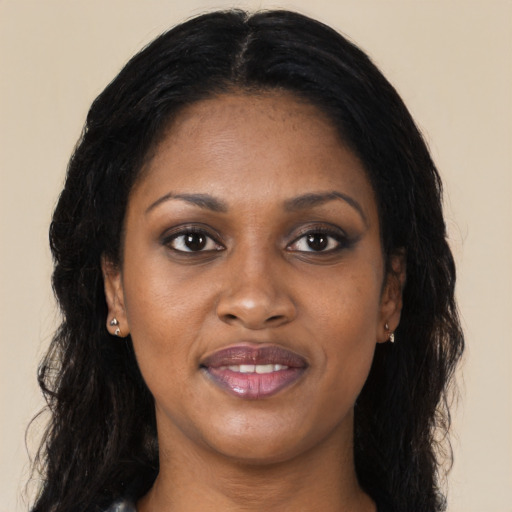 Joyful black young-adult female with long  brown hair and brown eyes