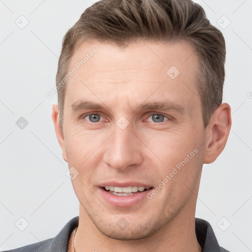 Joyful white adult male with short  brown hair and grey eyes