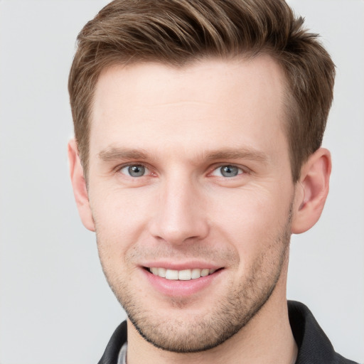 Joyful white young-adult male with short  brown hair and grey eyes