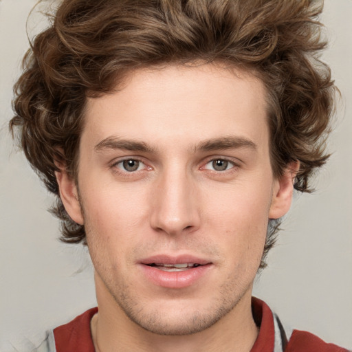 Joyful white young-adult male with short  brown hair and blue eyes