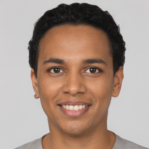 Joyful black young-adult male with short  black hair and brown eyes