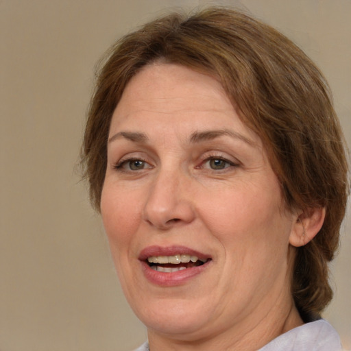 Joyful white adult female with medium  brown hair and green eyes