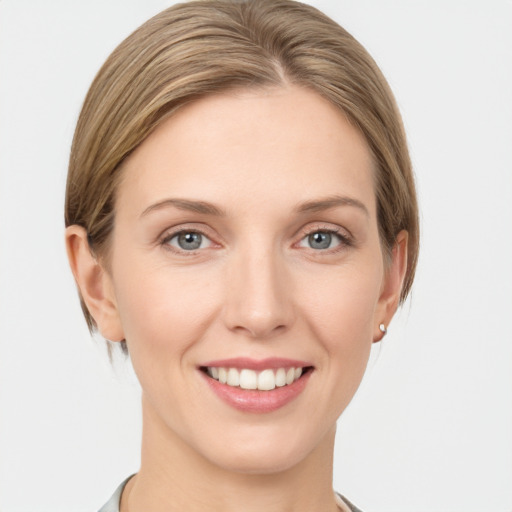 Joyful white young-adult female with medium  brown hair and grey eyes