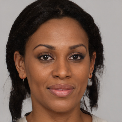 Joyful black adult female with medium  brown hair and brown eyes