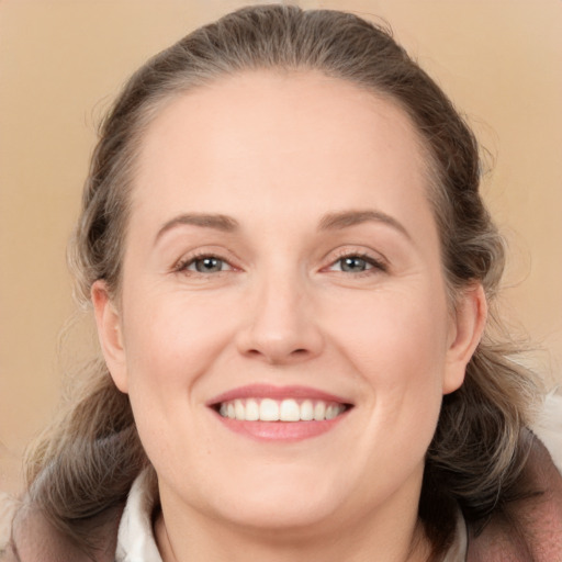 Joyful white adult female with medium  brown hair and grey eyes