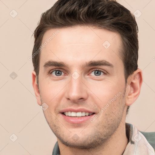 Joyful white young-adult male with short  brown hair and grey eyes