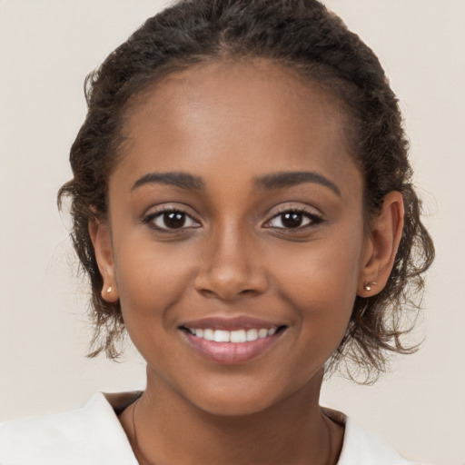 Joyful black young-adult female with long  brown hair and brown eyes