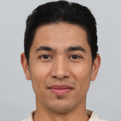 Joyful latino young-adult male with short  brown hair and brown eyes