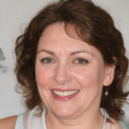 Joyful white adult female with medium  brown hair and blue eyes