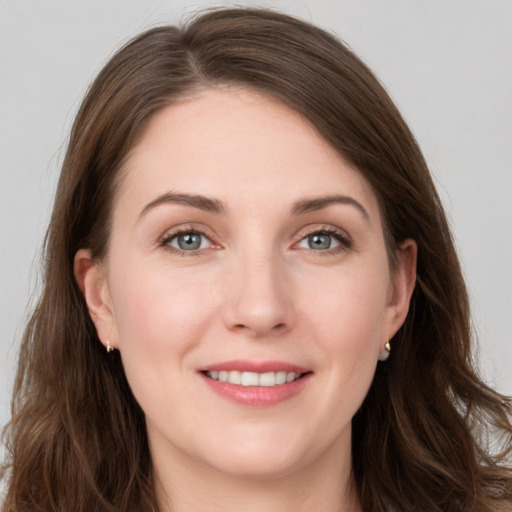 Joyful white young-adult female with long  brown hair and grey eyes