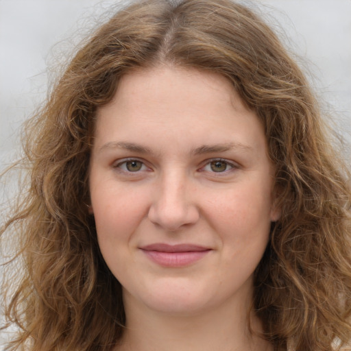 Joyful white young-adult female with long  brown hair and green eyes