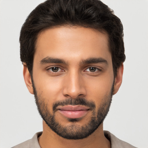 Joyful black young-adult male with short  brown hair and brown eyes