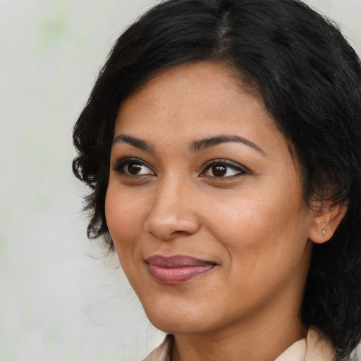 Joyful latino adult female with medium  brown hair and brown eyes