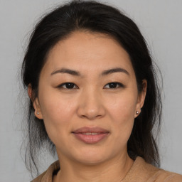 Joyful asian young-adult female with medium  brown hair and brown eyes