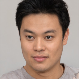 Joyful asian young-adult male with short  black hair and brown eyes