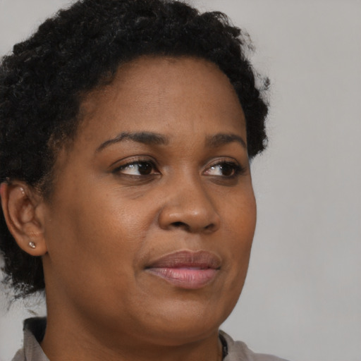 Joyful black young-adult female with short  brown hair and brown eyes