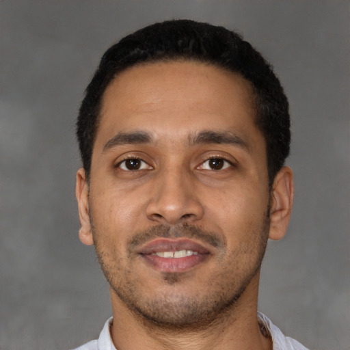 Joyful latino young-adult male with short  black hair and brown eyes