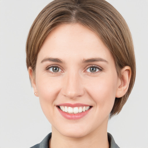 Joyful white young-adult female with medium  brown hair and grey eyes