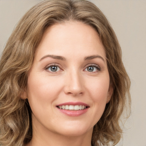 Joyful white young-adult female with long  brown hair and green eyes