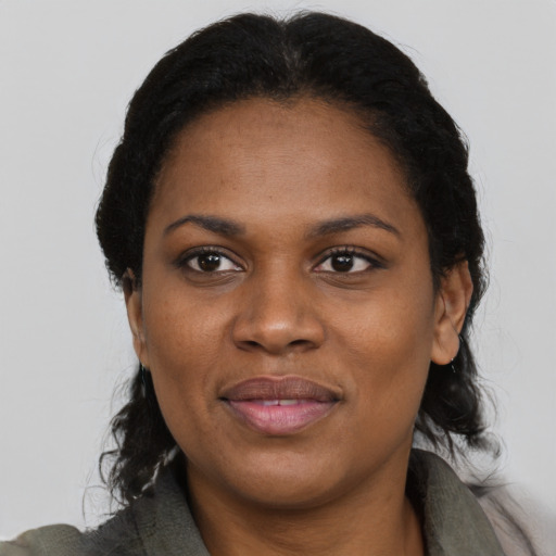Joyful black adult female with long  black hair and brown eyes
