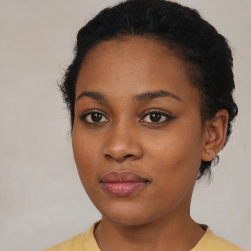 Joyful black young-adult female with short  black hair and brown eyes