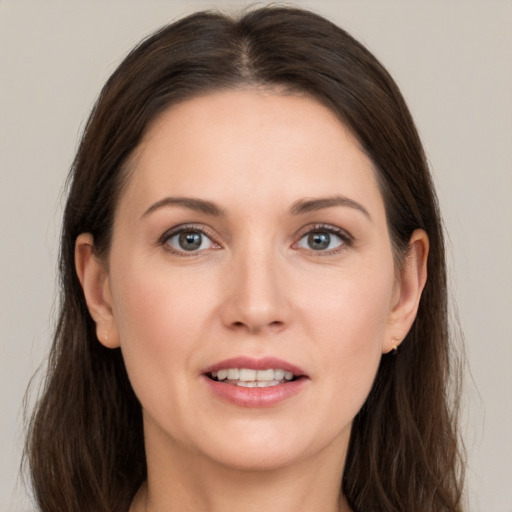 Joyful white young-adult female with long  brown hair and grey eyes