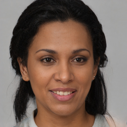 Joyful latino adult female with medium  brown hair and brown eyes